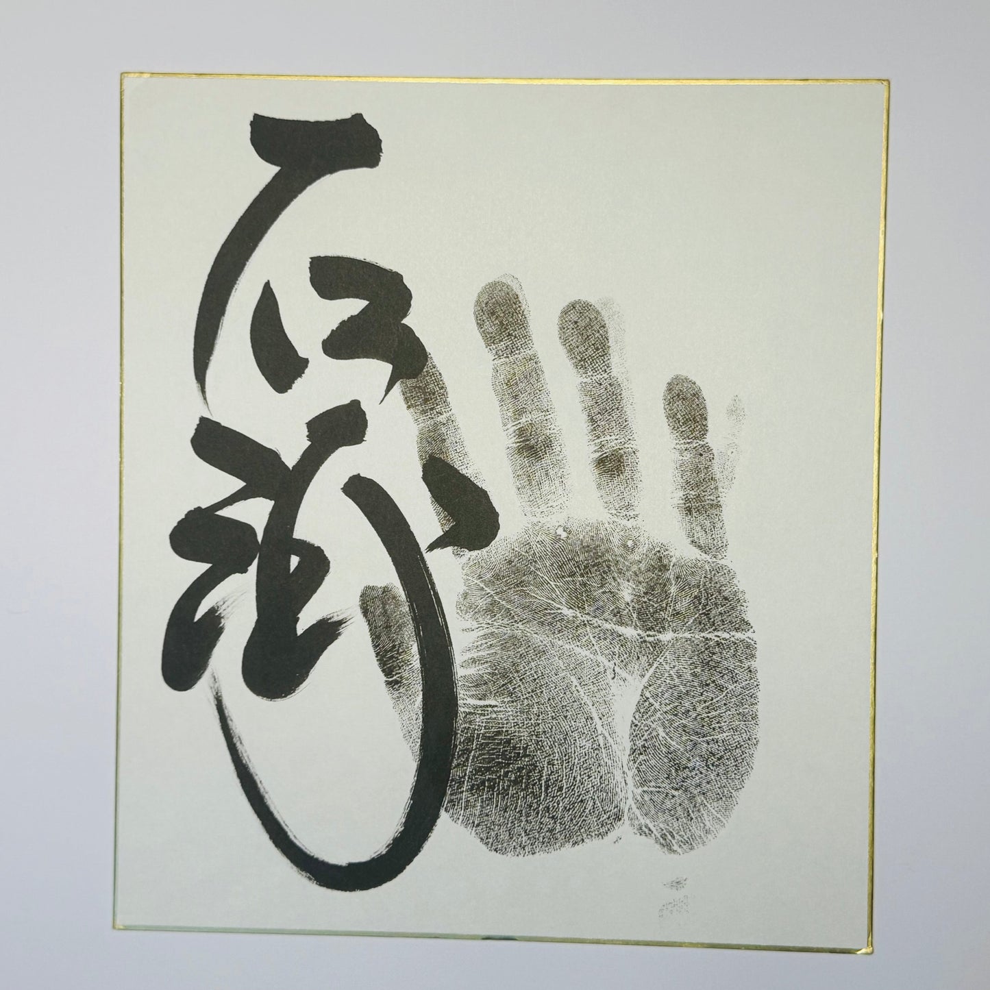 Calligraphy and handprint on cream background