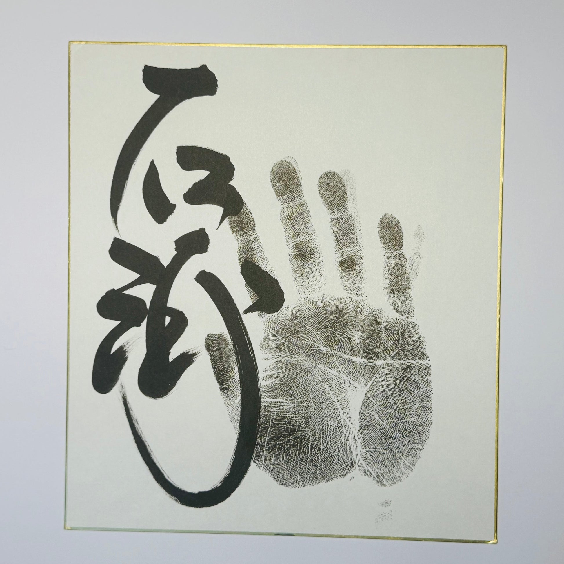 Calligraphy and handprint on cream background